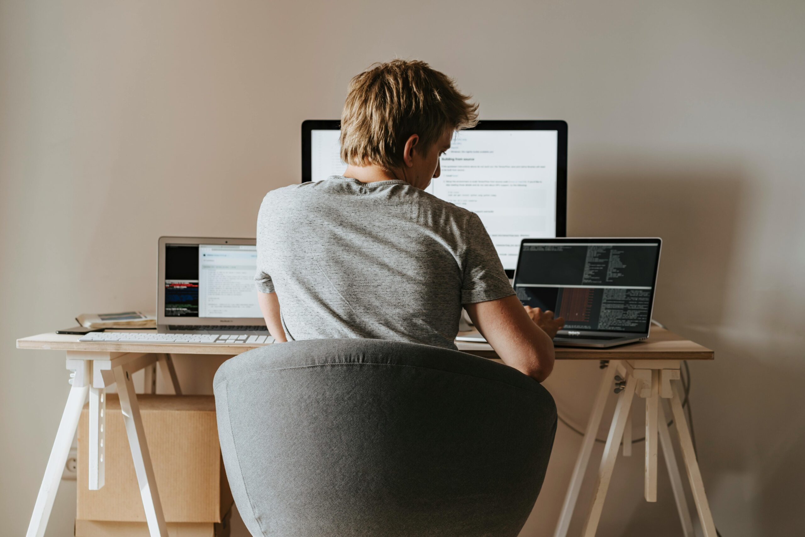 A person sitting at a desk, typing on a laptop, representing a freelancer working from home.